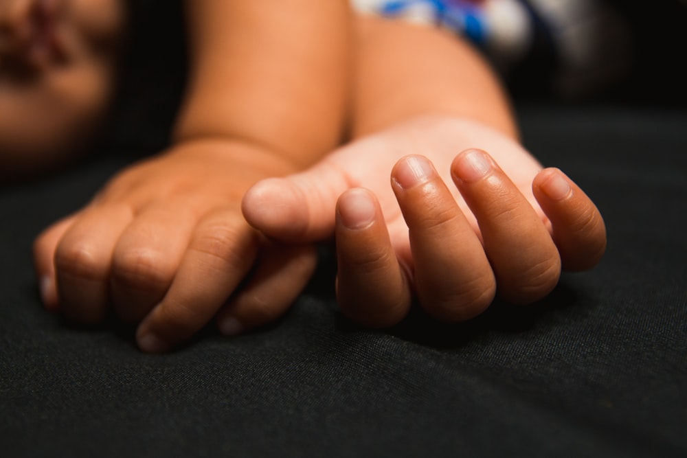 babys feet on black textile