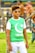 A young person wearing sunglasses and a green shirt featuring a crescent and star symbol paired with the words 'I Love Pakistan.' They are standing outdoors next to a tree, with a blurred background hinting at other people and greenery.