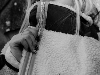 woman in black and white coat holding white leather bag onlyfans