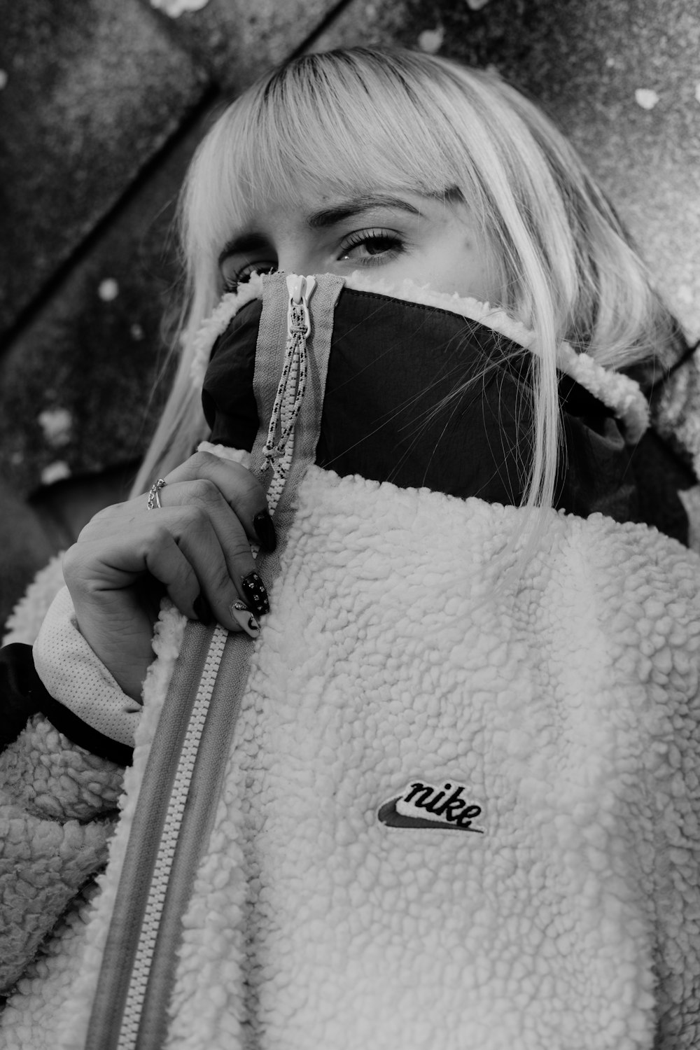 woman in black and white coat holding white leather bag