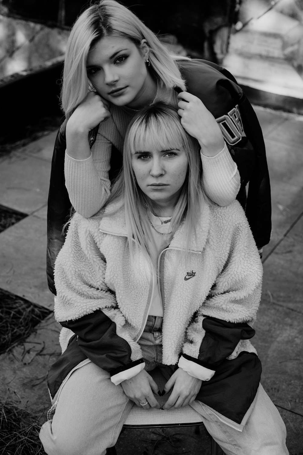 woman in white sweater and black pants sitting on concrete floor