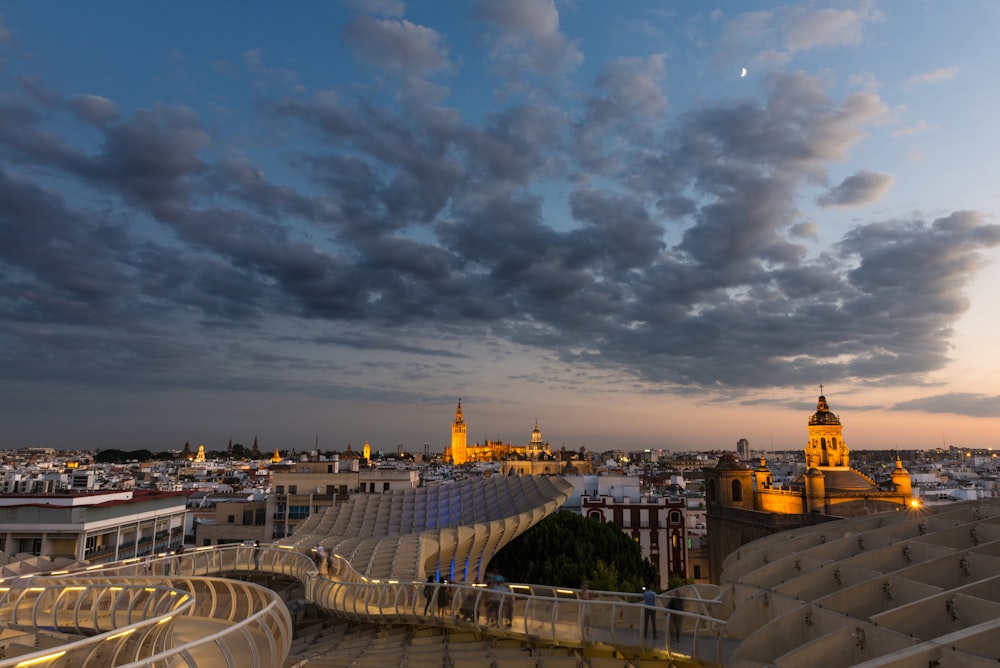 city buildings under gray clouds during night time