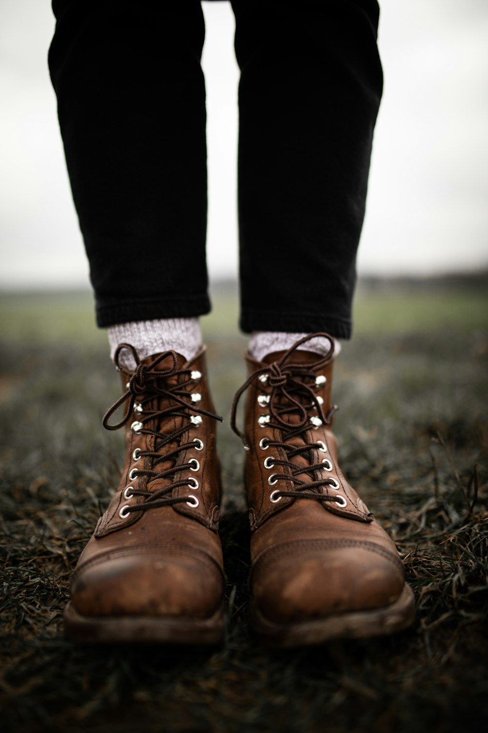 person in black pants and brown hiking shoes