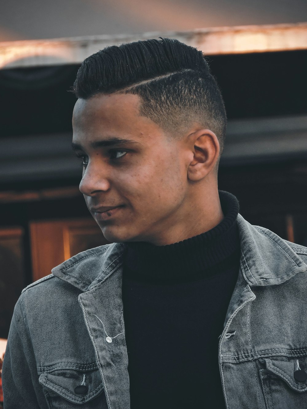 man in black turtleneck shirt and gray denim jacket