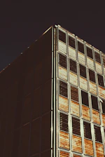 A sleek modern building facade showcasing aluminum and wood elements under bright daylight.