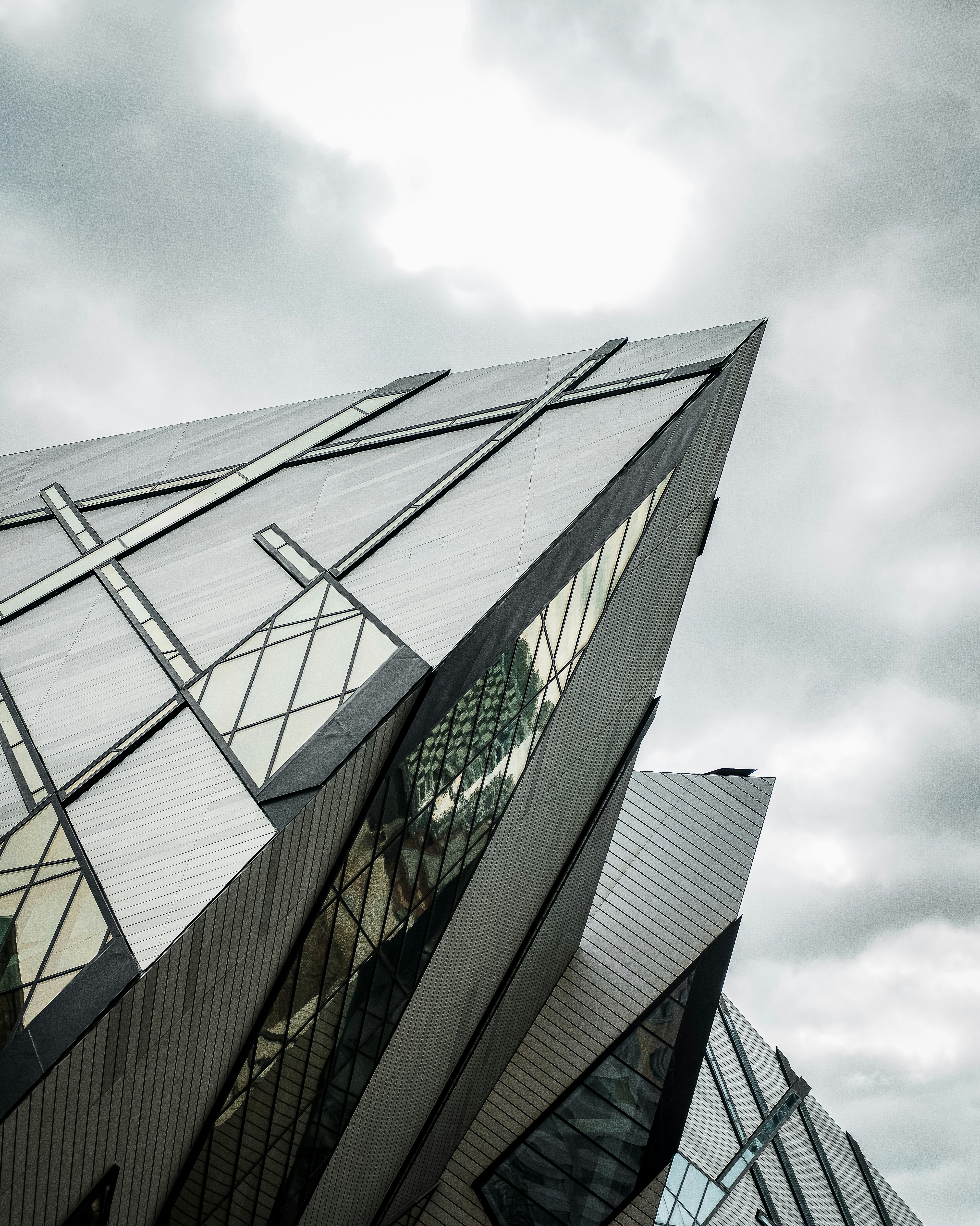 glass walled building under white clouds during daytime