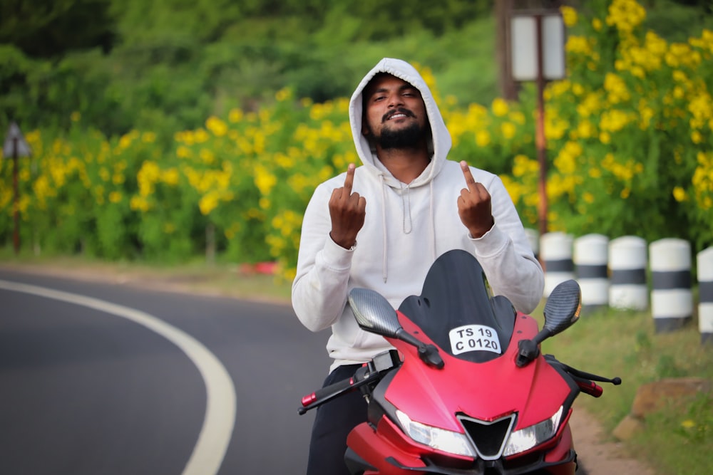 woman in white hijab riding red motorcycle