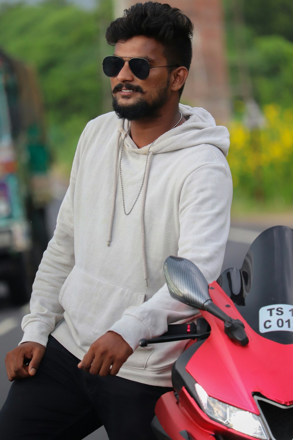 man in white hoodie riding red motorcycle