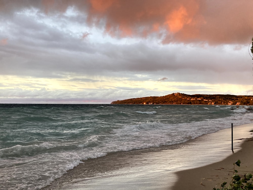 ocean waves crashing on shore during sunset