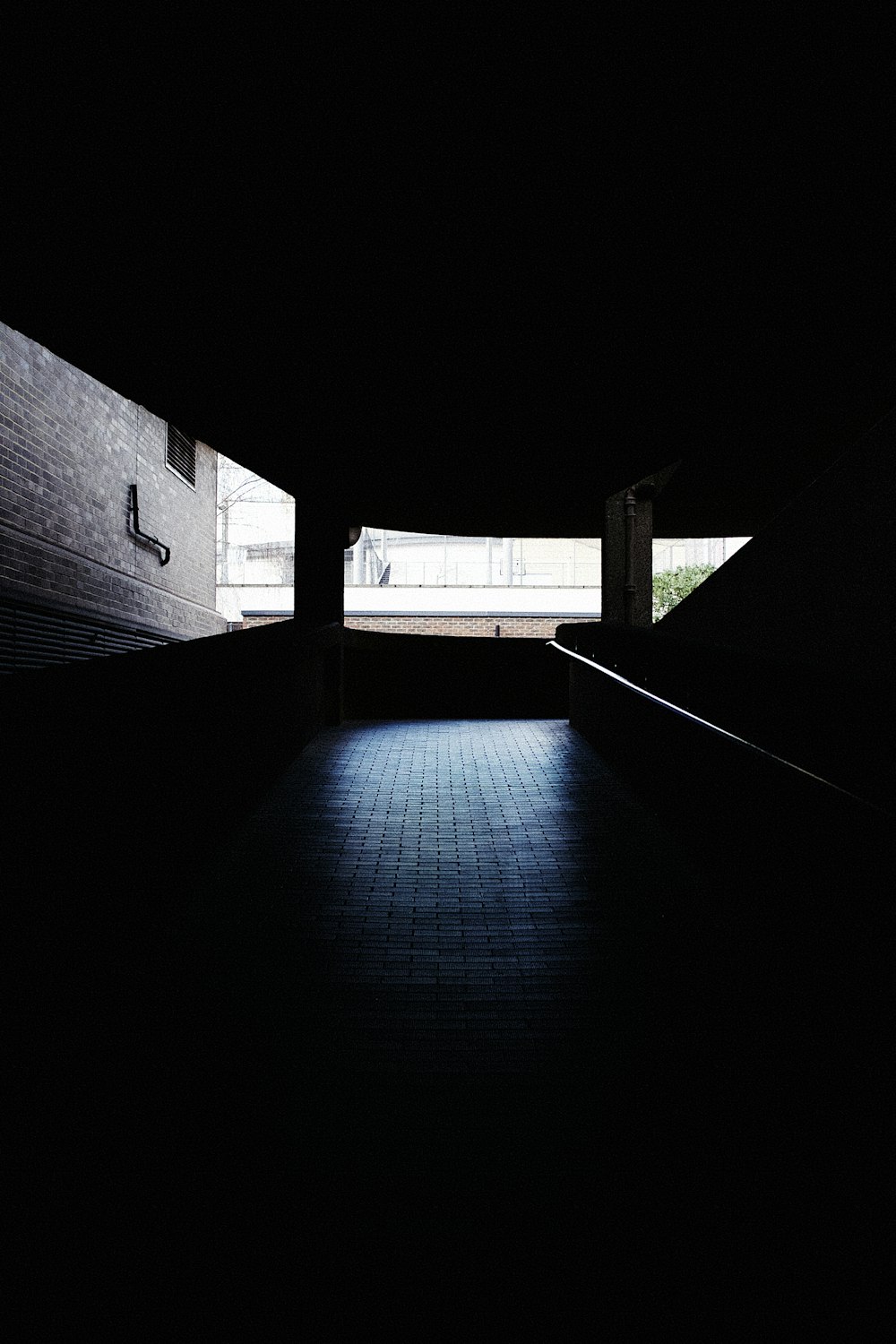 black concrete hallway with white wall