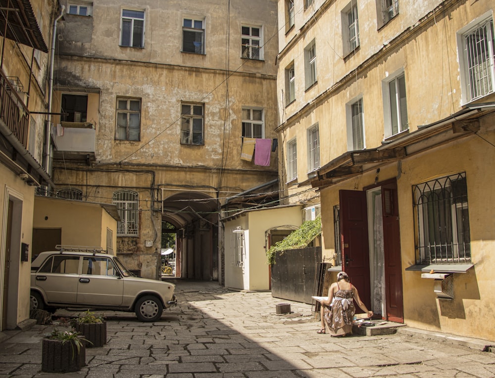 white car parked beside brown concrete building during daytime