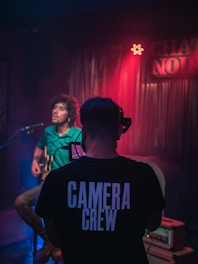 man in black crew neck t-shirt standing in front of microphone
