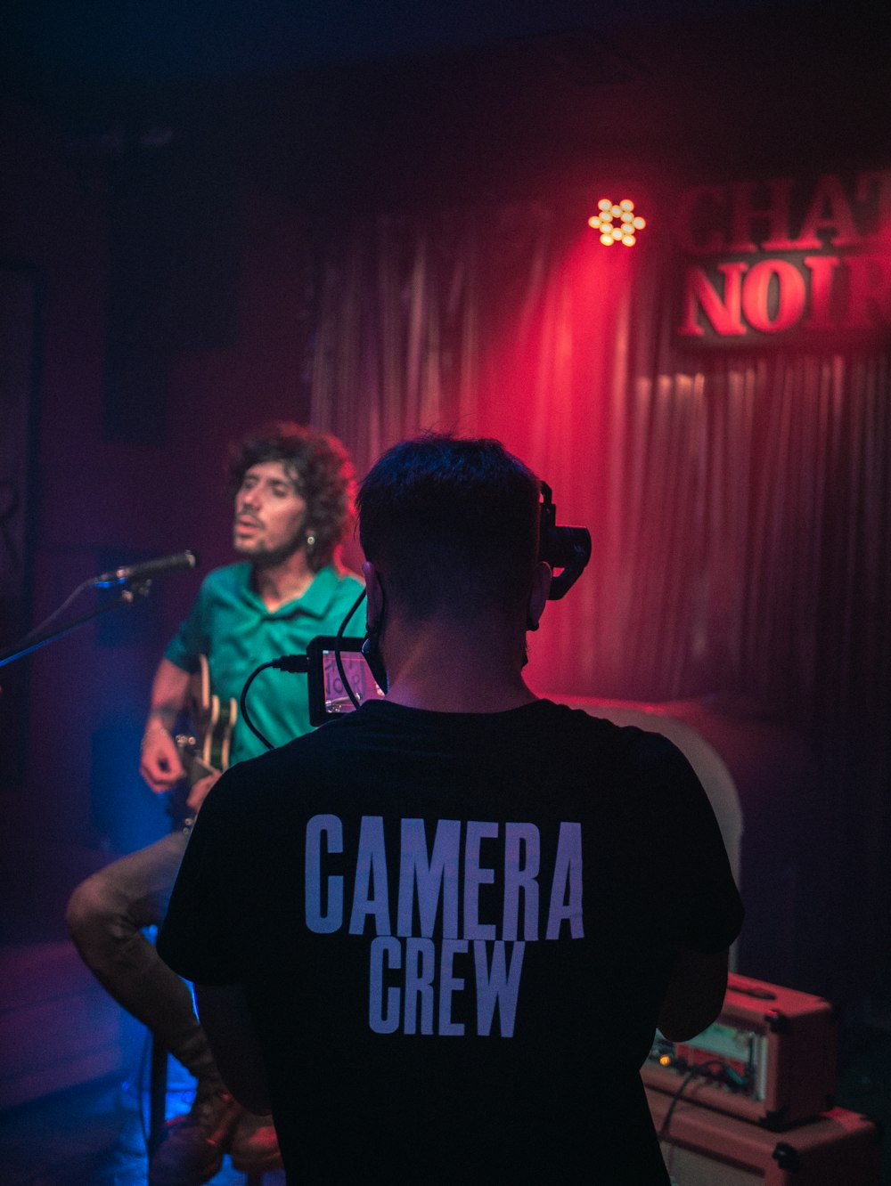 man in black crew neck t-shirt standing in front of microphone