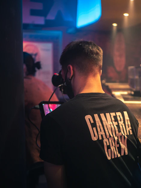 A candid shot of Darryl Moore working behind a camera on a vibrant video set.