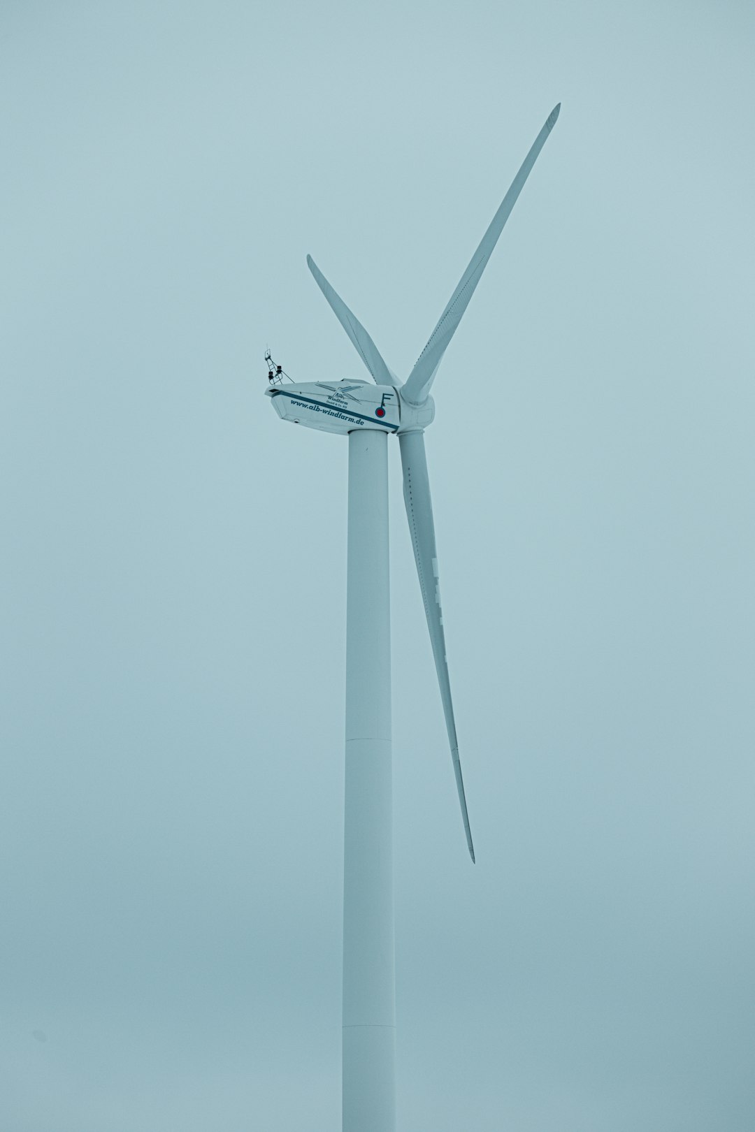 white wind turbine under blue sky