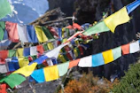 Colorful prayer flags fluttering against the backdrop of Kinnaur’s rugged cliffs.