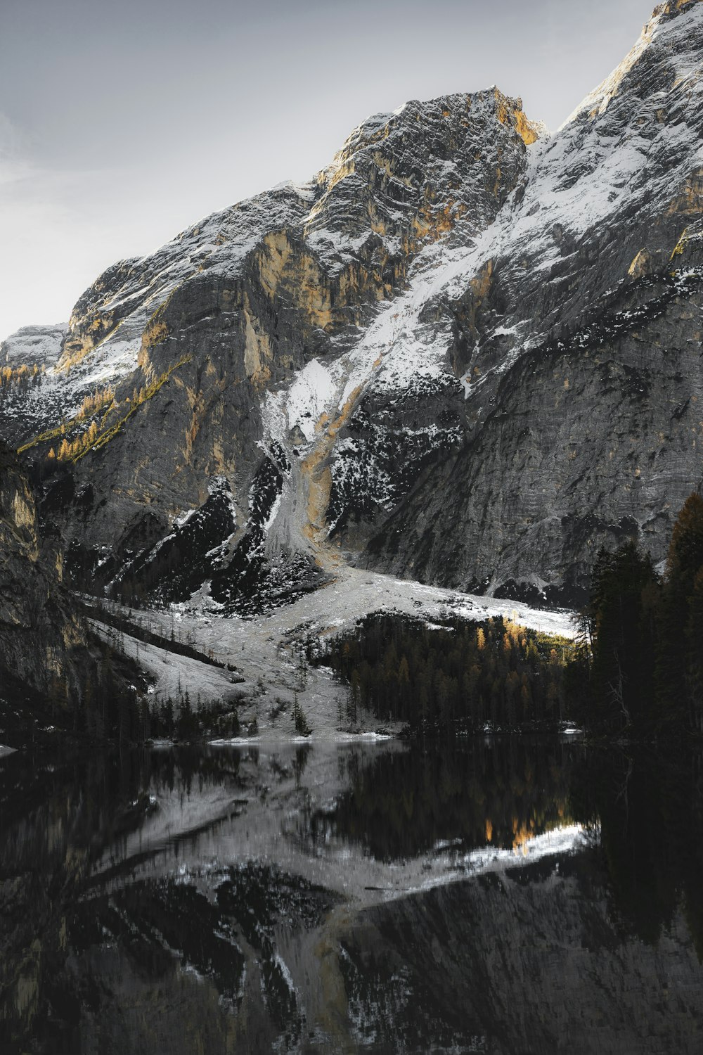 snow covered mountain near lake during daytime