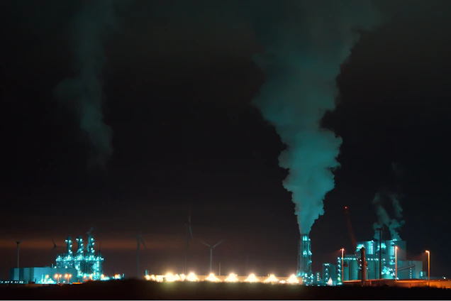 A sleek, dark-themed photo of a modern biochar production facility with subtle green lighting accents highlighting advanced machinery.