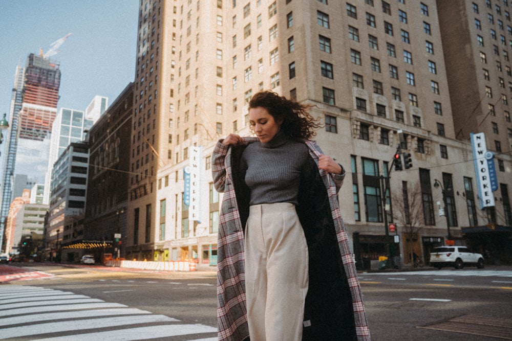 woman in black coat standing on pedestrian lane during daytime