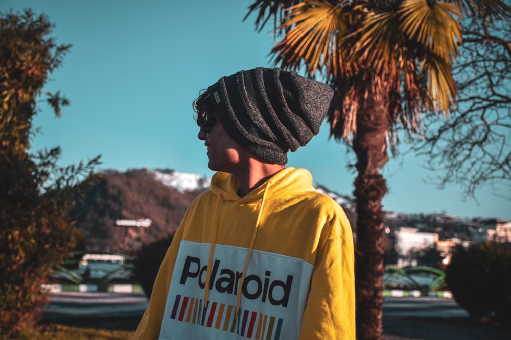 man in yellow and white shirt wearing black and white knit cap