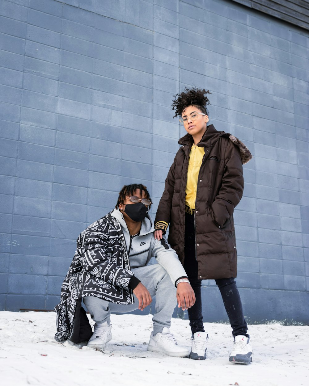 man and woman standing on snow covered ground