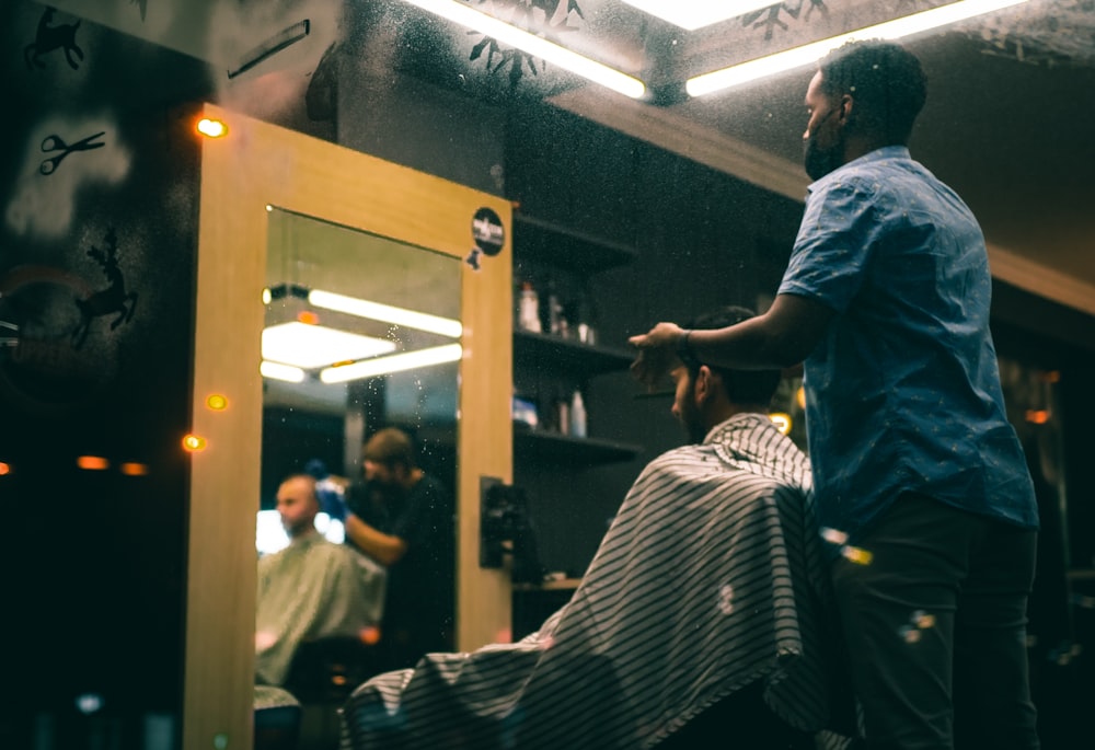 man in gray t-shirt standing in front of mirror