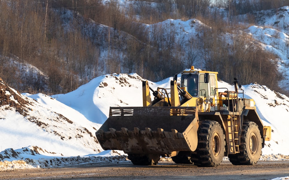 yellow and black heavy equipment on snow covered ground during daytime