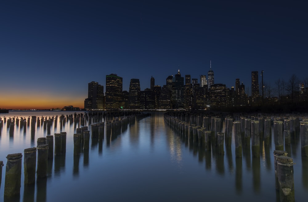 city skyline across body of water during night time