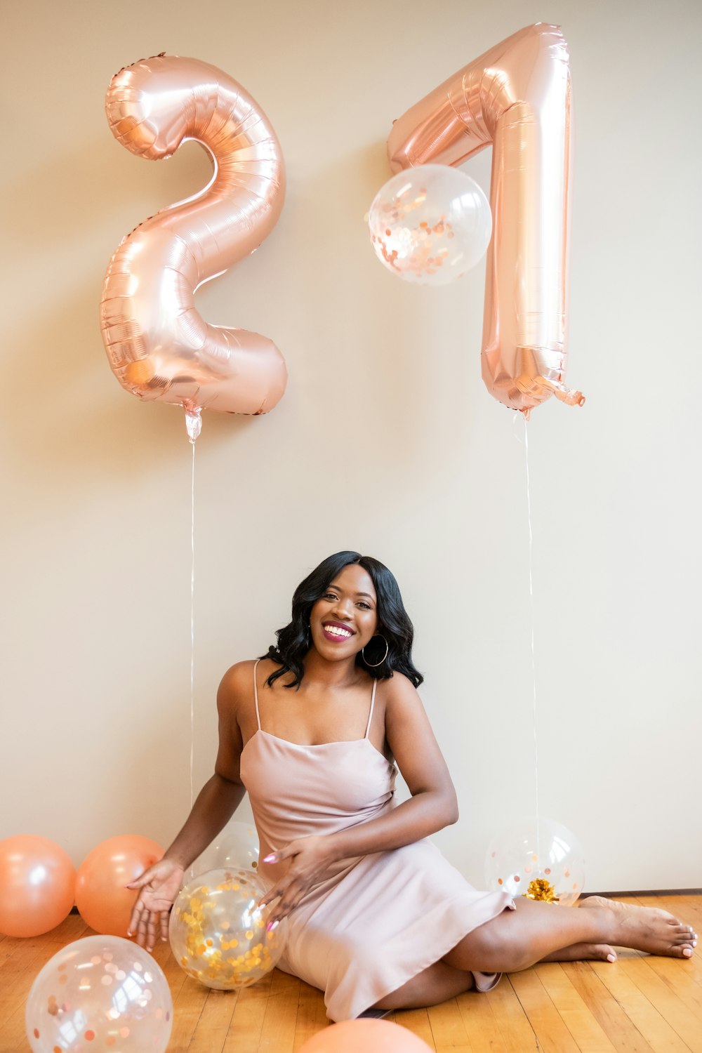 woman in white spaghetti strap dress holding balloons