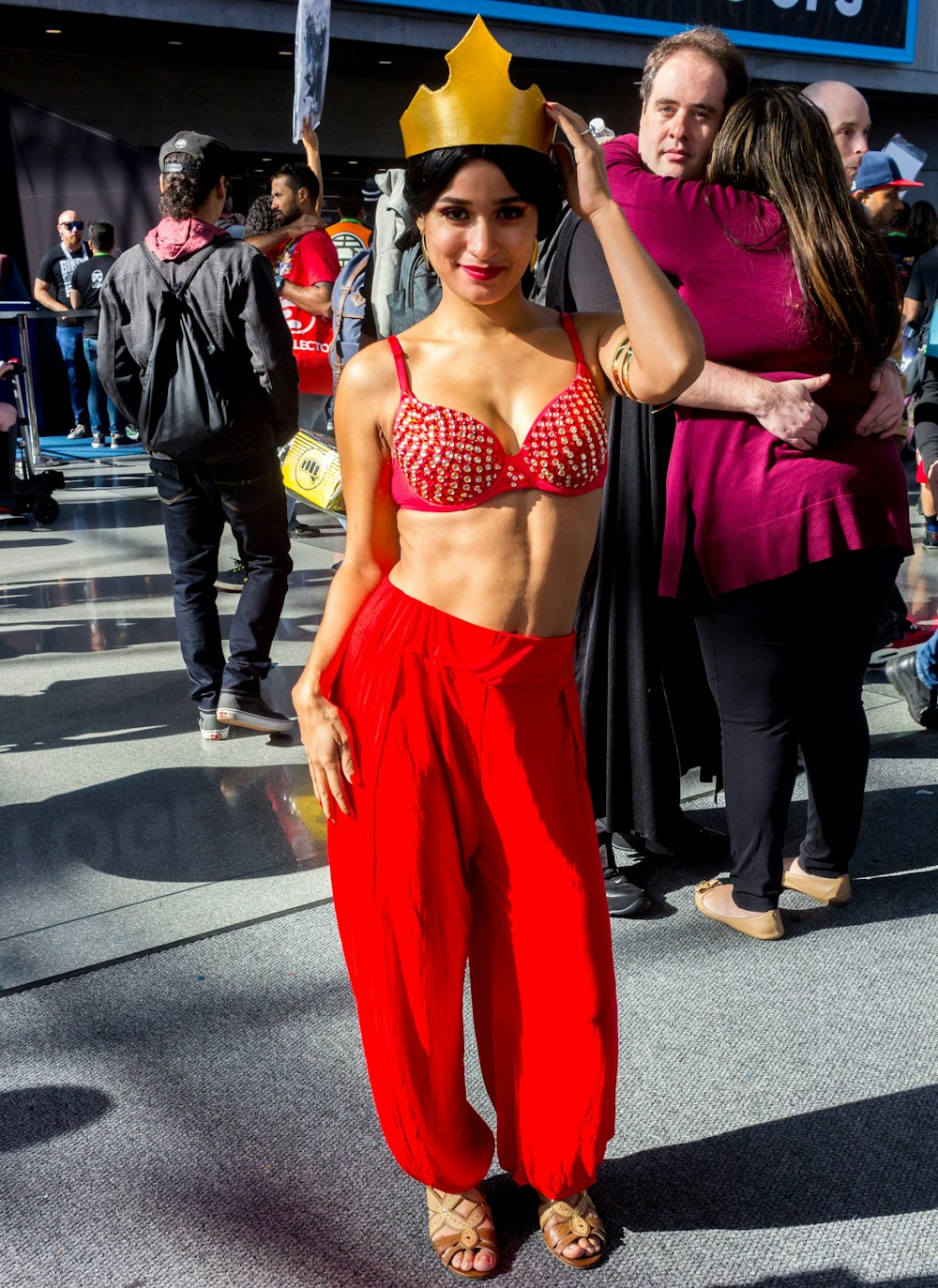 woman in black brassiere and red pants standing on street during daytime