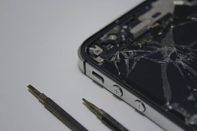 Close-up of a cracked Samsung smartphone screen being carefully repaired.