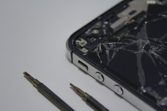 A friendly technician carefully repairing a cracked smartphone screen.