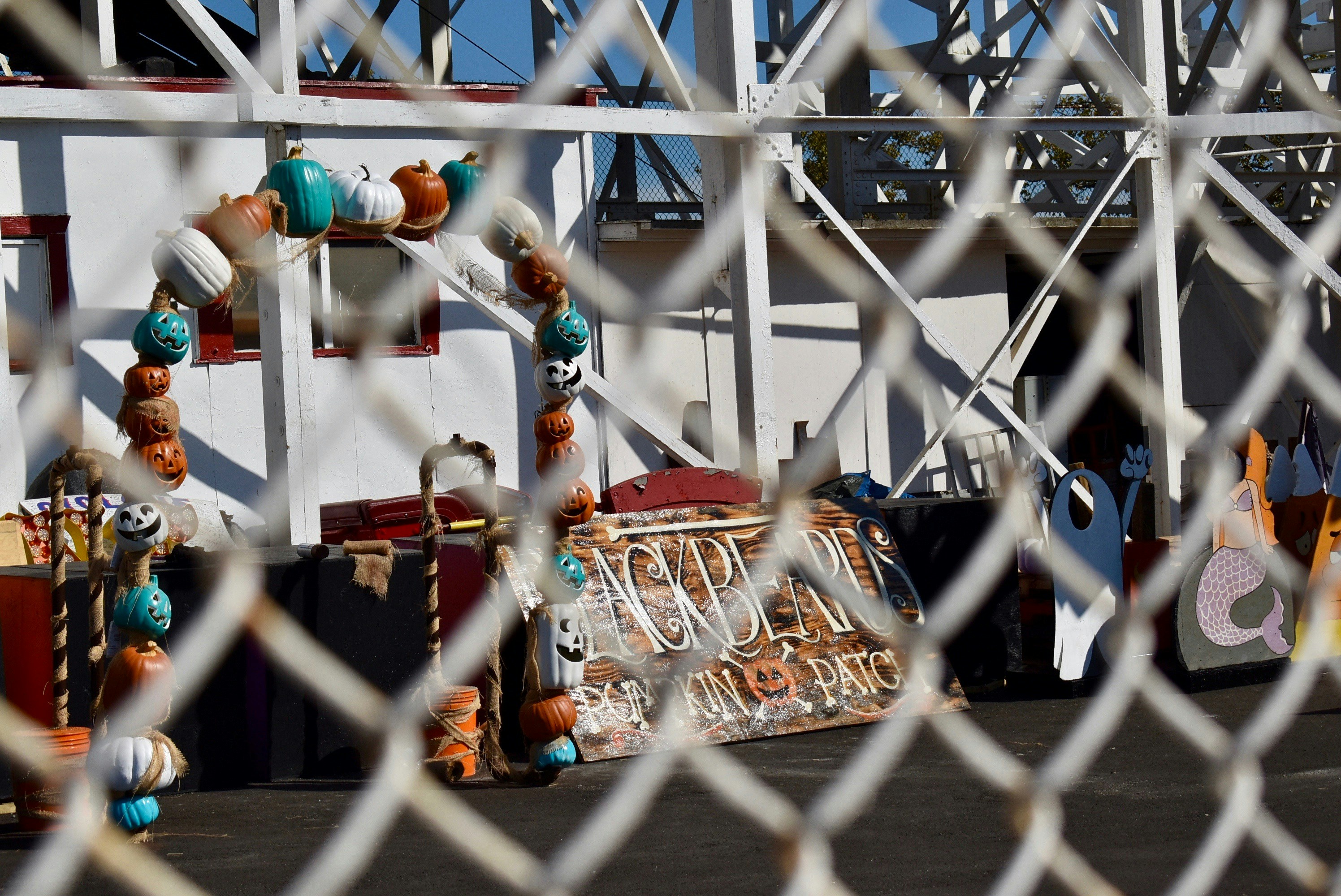 people in blue and orange shirt standing on white metal fence during daytime