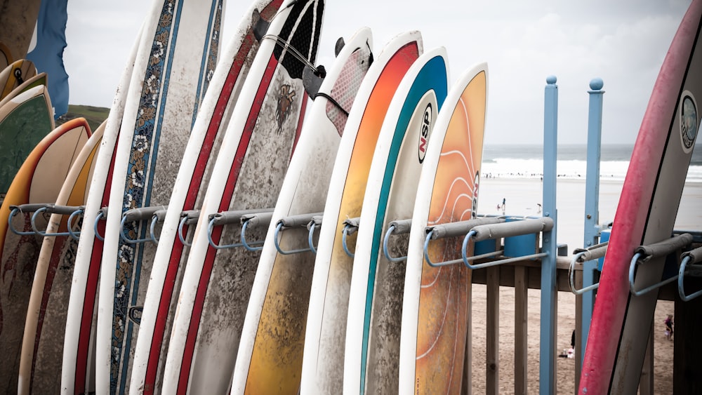 Tavola da surf bianca e blu su recinzione di legno marrone durante il giorno