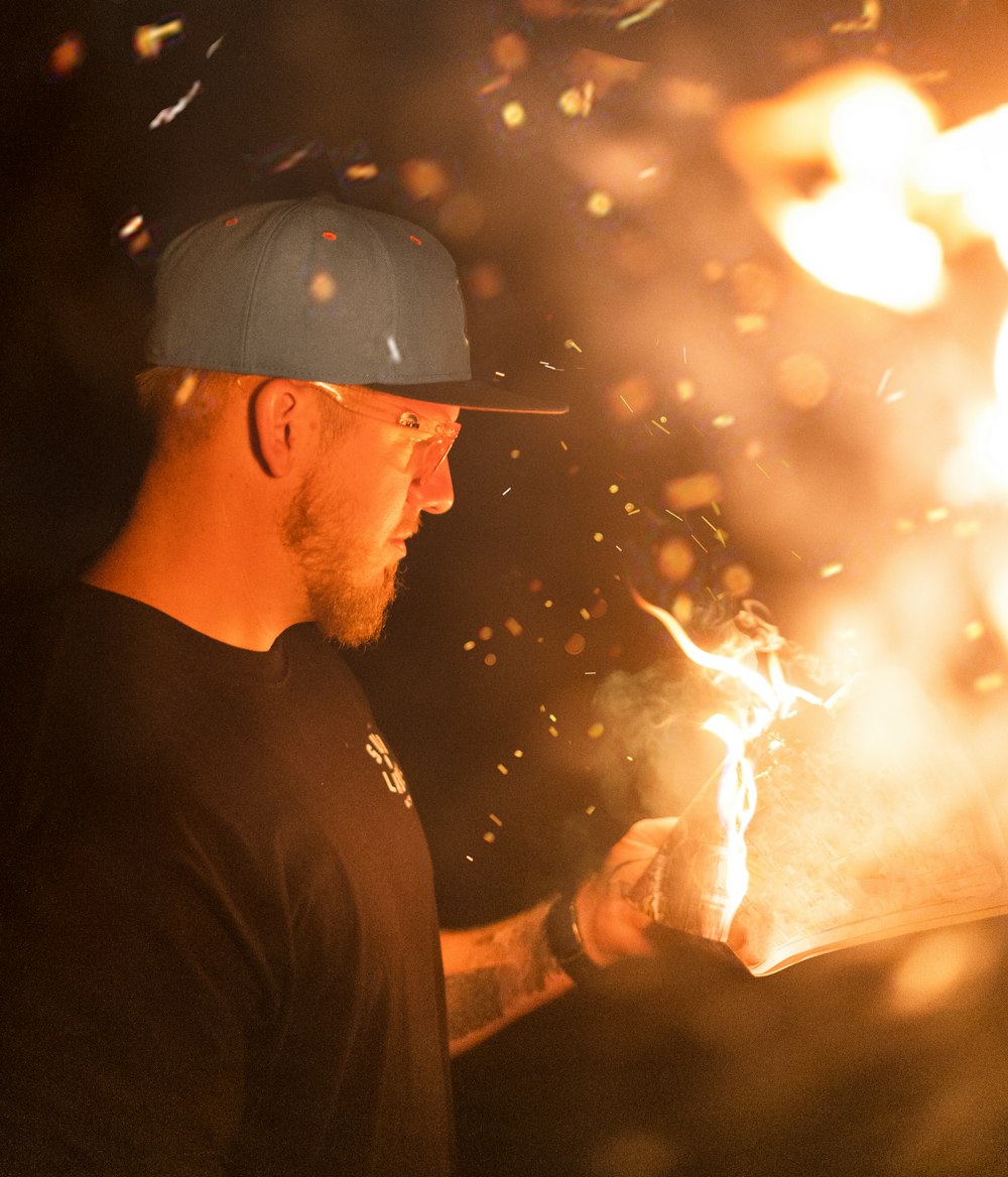 man in black crew neck shirt holding fire