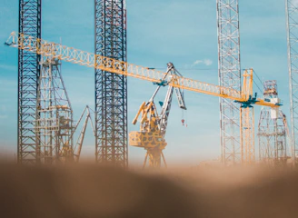 Modern construction site with cranes and workers collaborating under clear sky.