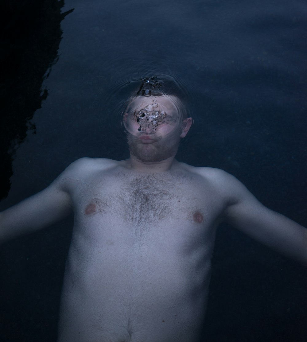 topless man in water during daytime