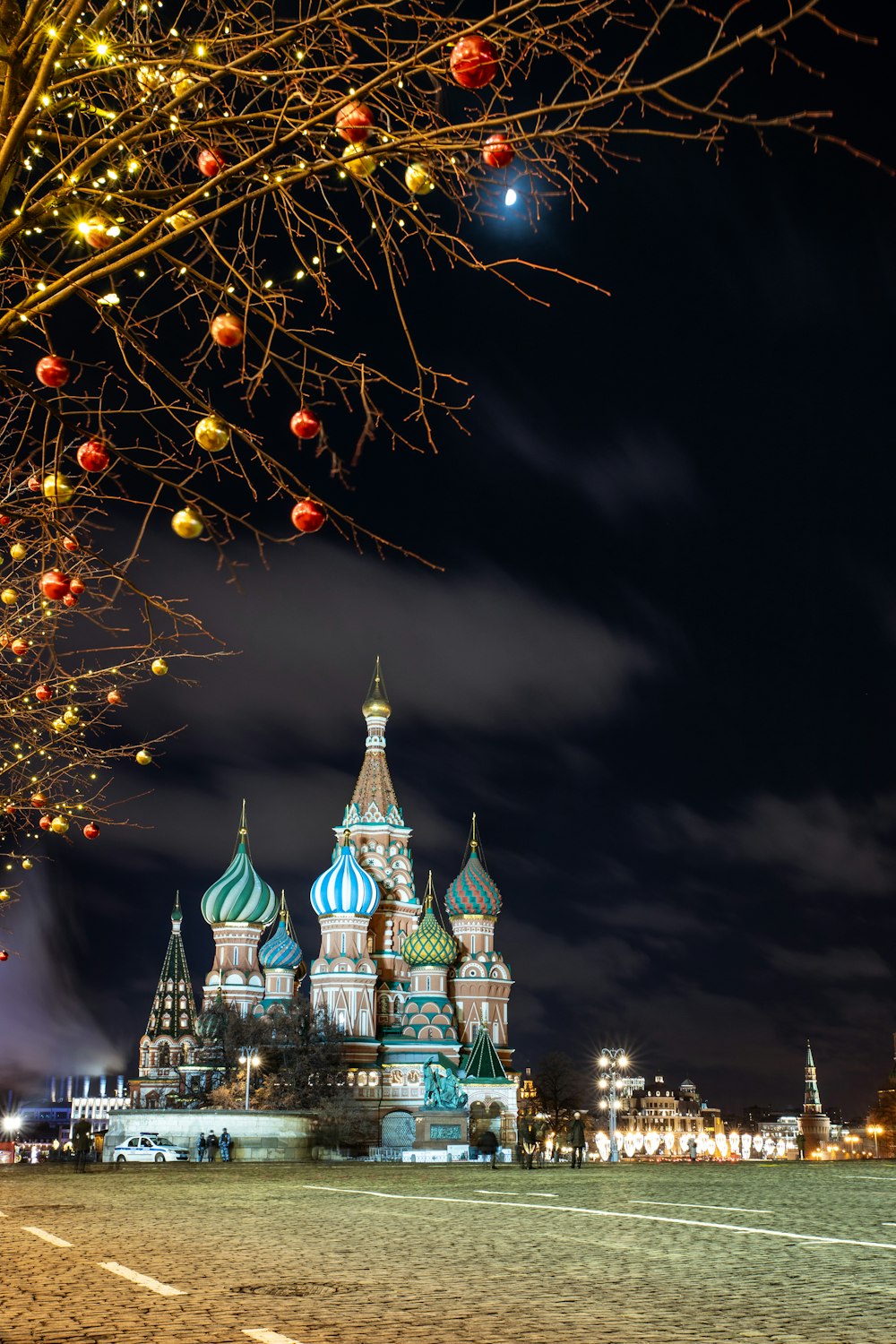 beleuchteter Weihnachtsbaum in der Nähe von weißem und blauem Schloss während der Nachtzeit