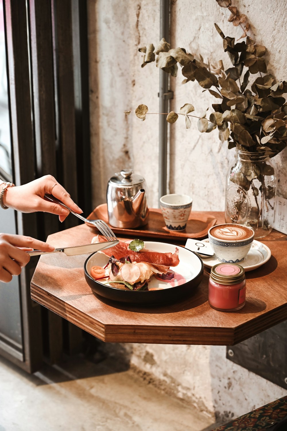 person holding silver fork and knife on white ceramic plate