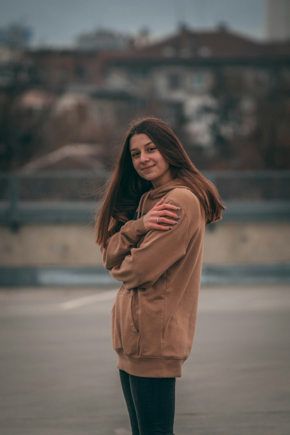 woman in brown coat standing on road during daytime