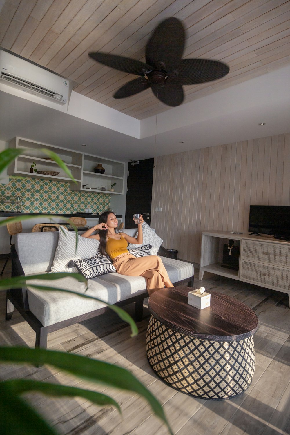 woman in white and black stripe shirt sitting on white and black sofa chair