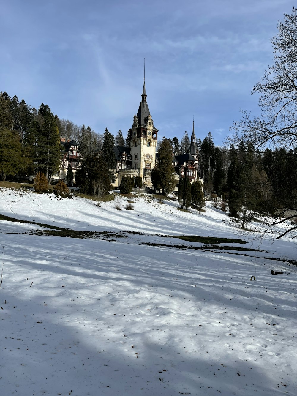 Bâtiment en béton brun et blanc entouré d’arbres sous un ciel bleu pendant la journée