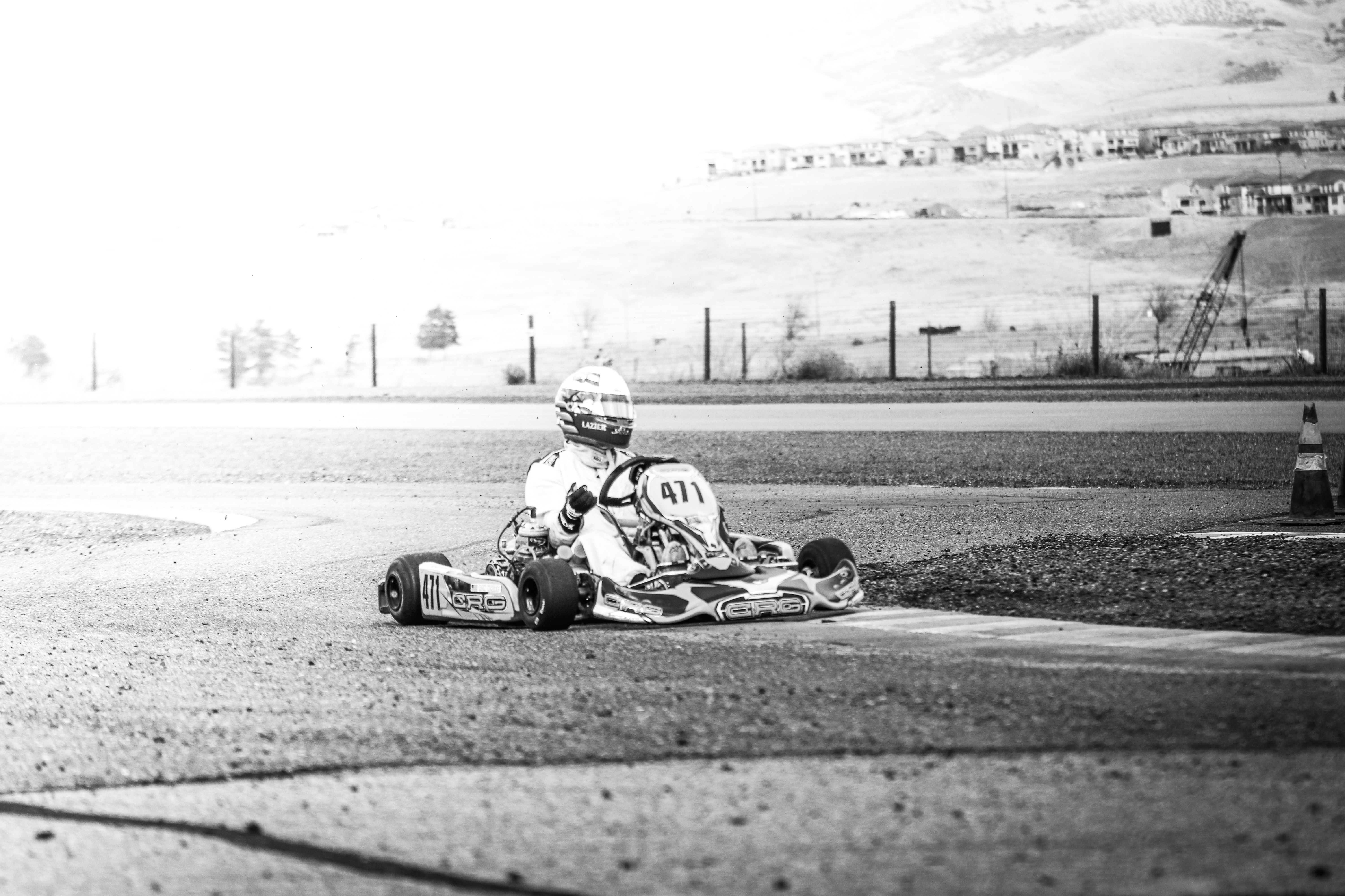 grayscale photo of man riding on go kart