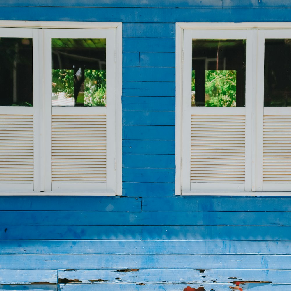 blue wooden window frame on blue concrete wall