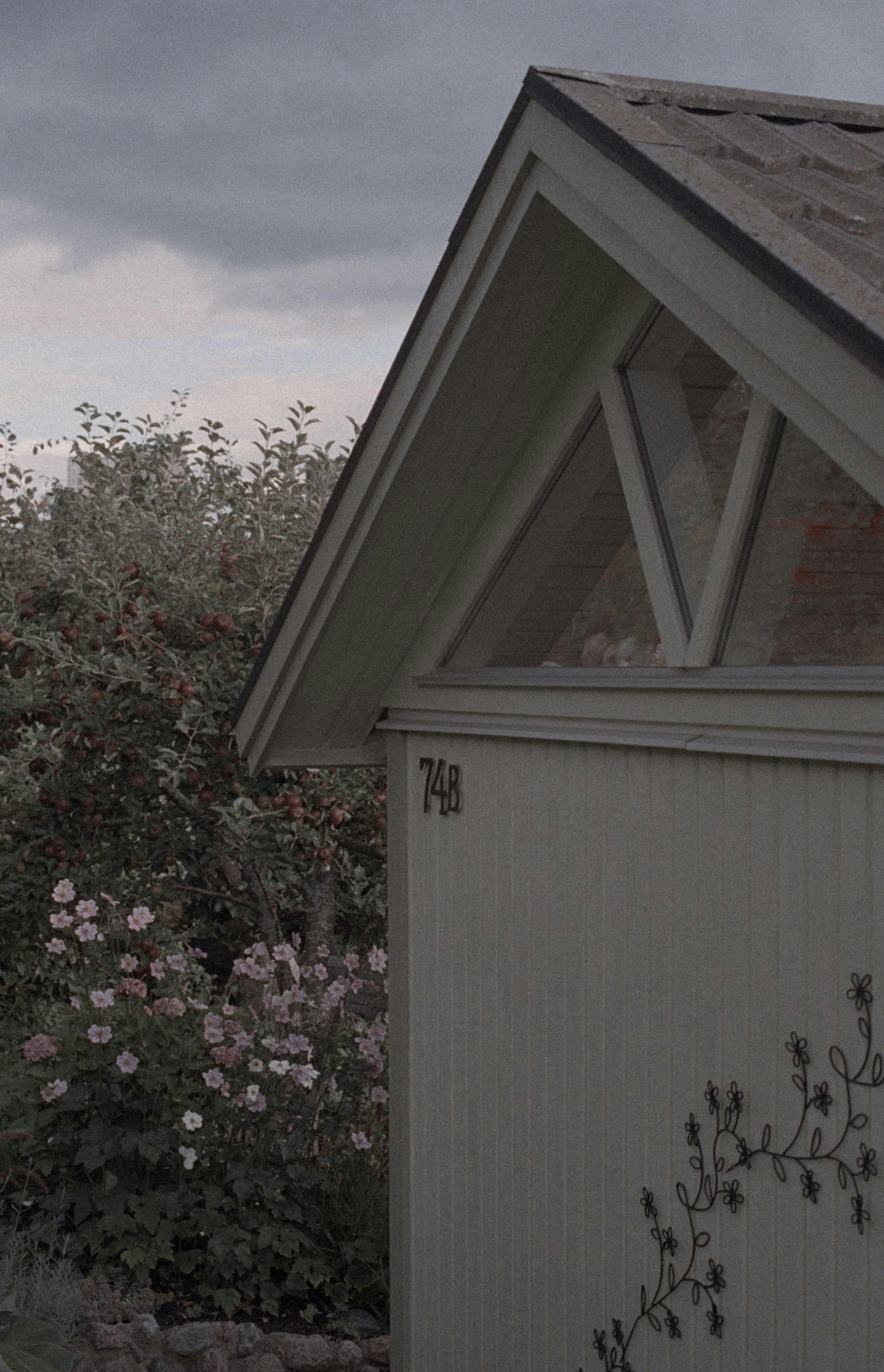 weißes Holzhaus mit rosa Blumen