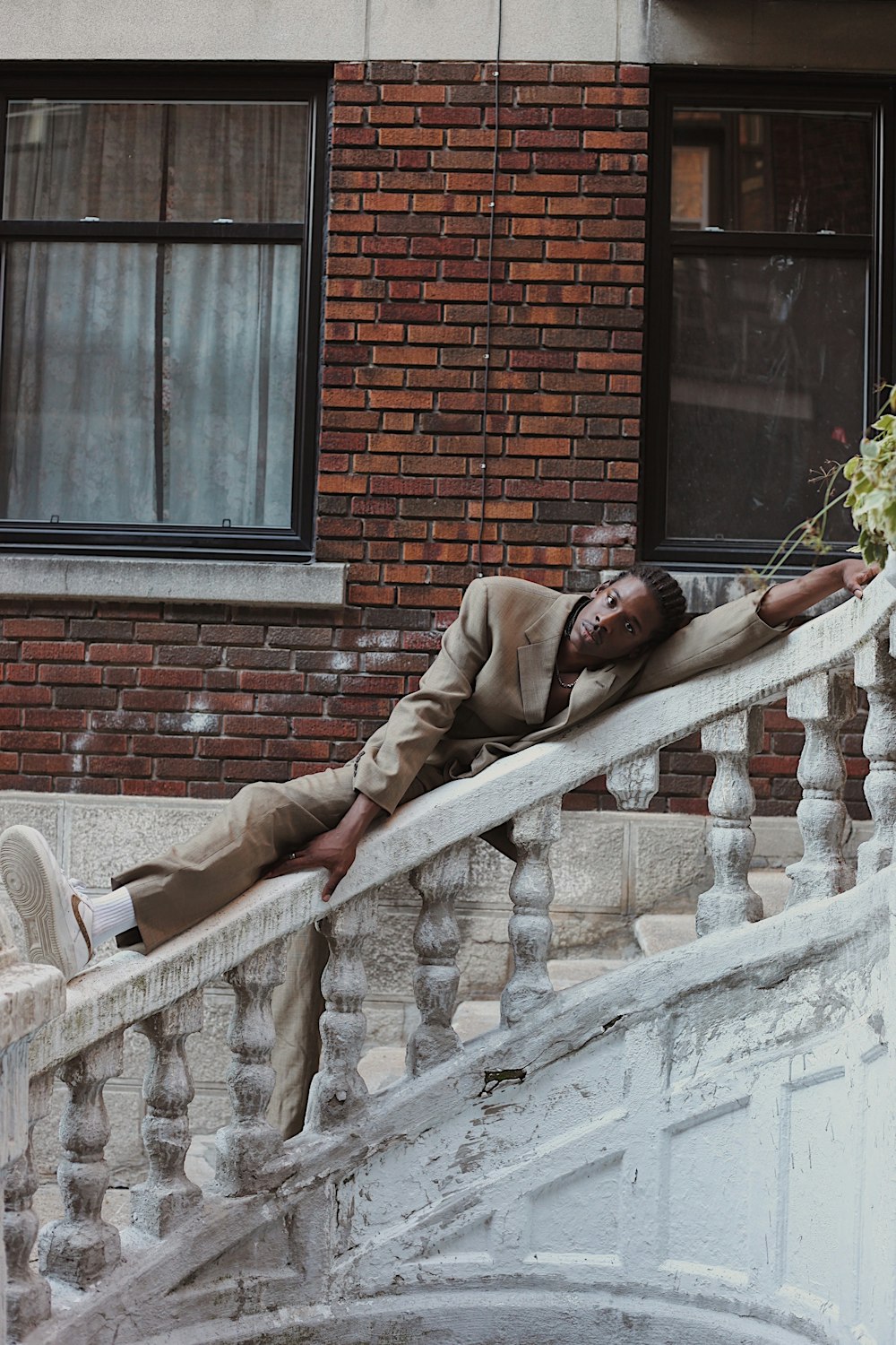 man in brown jacket lying on white bench during daytime