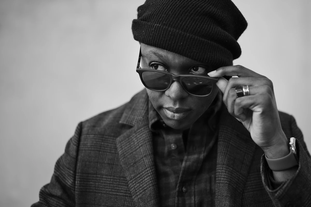 Black and white portrait of a man lowering his dark sunglasses