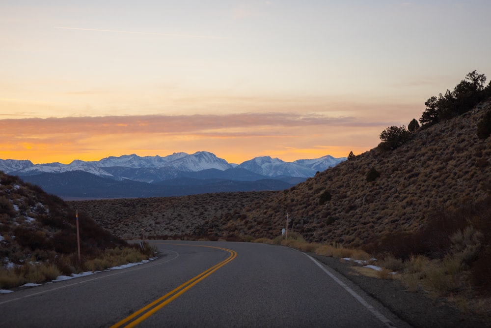 gray concrete road near mountains during daytime