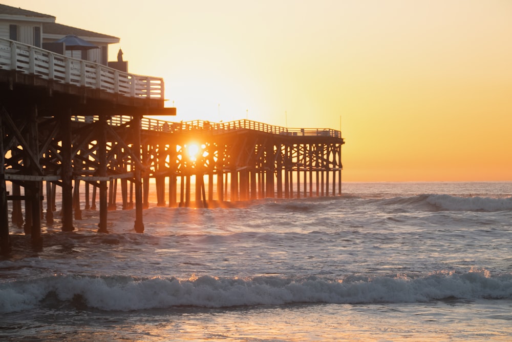 brown wooden dock on sea during sunset