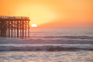 brown wooden dock on sea during sunset